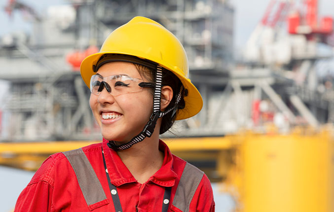 woman in PPE smiling in front of Whale platform (photo)