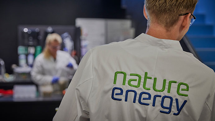 Nature Energy employee in the laboratory wearing a branded lab coat