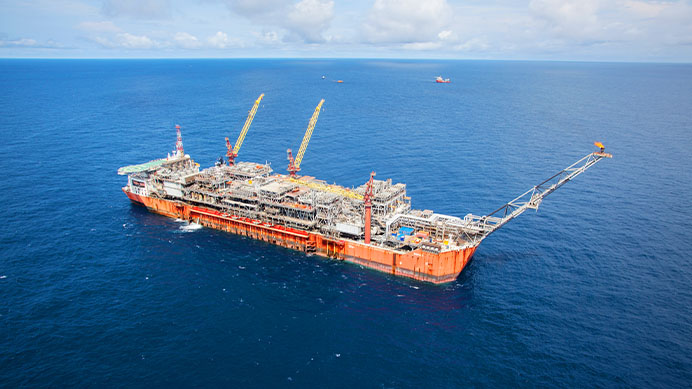 An offshore oil and gas platform with cranes in the ocean (photo)