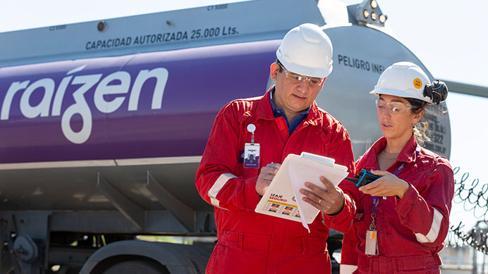 two employees from Raizen standing infront of a Raizen branded tanker