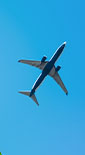view looking up of airplane travelling through blue sky (photo)