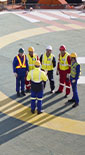 group of men wearing PPE having a Safety briefing on a helipad (photo)
