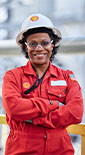 Smiling Shell employee in PPE with her arms crossed at Shell facility in USA (photo)