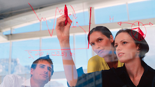 Businesswoman drawing graphs on glass. (photo)