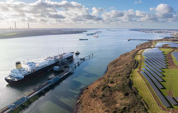 Image of the Dragon terminal, an LNG receiving, storing and regasification facility in Waterston, near Milford Haven in Pembrokeshire, Wales alongside multiple solar panels onshore. (photo)