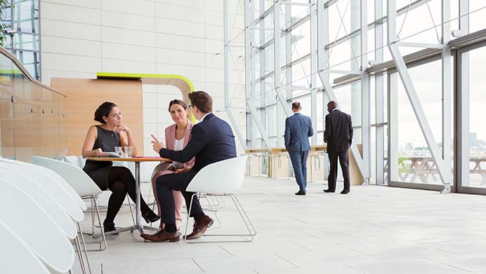 A group of three business executives holding a meeting in an office breakout area (photo)